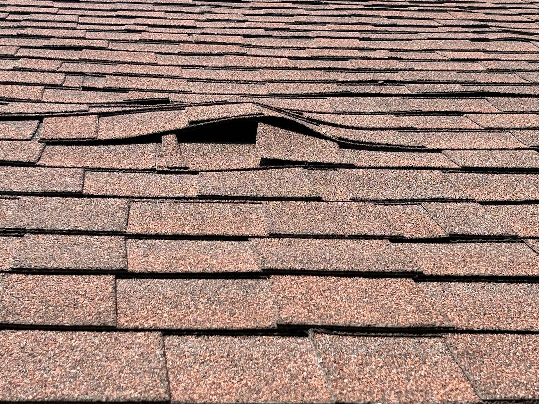 Why Are There Buckled Sections on My Shingled Roof, and Could Damaged Roof Decking Be the Cause?